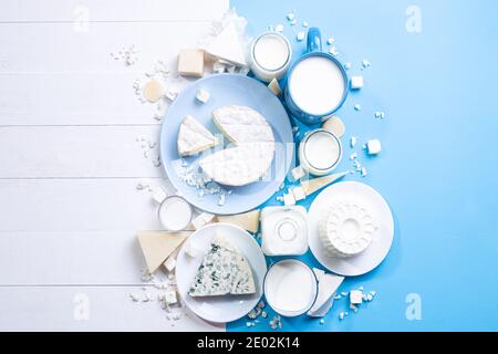 Produits laitiers sur bois blanc et fond bleu avec espace de copie. Vue de dessus, plat. Banque D'Images
