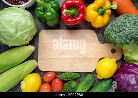 Fruits et légumes frais avec planche à découper en bois. Espace de copie. Concept alimentaire végétalien. Arrière-plan sain. Banque D'Images