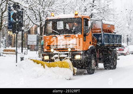 Un chasse-neige au travail pendant les chutes de neige sur les rues blanchies à la chaux dans la ville Banque D'Images