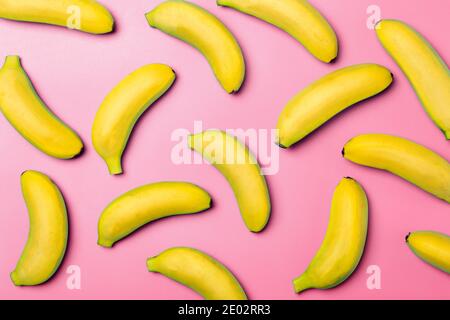 Bananes sur fond coloré. Motif de bananes fraîches jaunes sur fond rose pur. Concept minimaliste et créatif. Banque D'Images