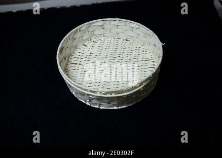 Panier en osier blanc pour le transport de pain et de fruits isolé sur fond noir, fait à la main Banque D'Images