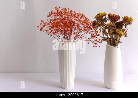 Gypsophila et chrysanthèmes séchés dans des vases blancs, œuvres florales faites à la main Banque D'Images