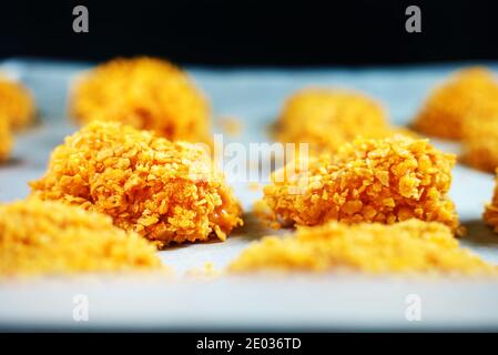 Nuggets de poulet sur papier parchemin avant la cuisson. Banque D'Images