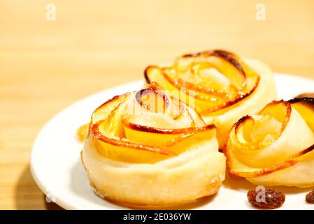 Gros plan de délicieux roses aux pommes jaunes pâte feuilletée gâteaux, fond flou Banque D'Images