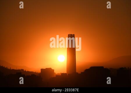 Soleil derrière un gratte-ciel à Santiago de Chile Banque D'Images