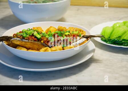 Plats traditionnels chinois maison épicés et chauds, poisson frit et tofu sur plat blanc, alimentation saine Banque D'Images