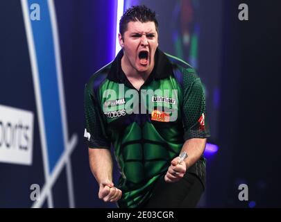 Daryl Gurney célèbre après avoir remporté un jeu contre Chris Dobey pendant le douze jour du Championnat du monde des fléchettes William Hill à Alexandra Palace, Londres. Banque D'Images
