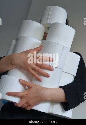 Mains de femmes asiatiques, porter et stocker le papier toilette, crise du papier, concept de pandémie, vertical Banque D'Images