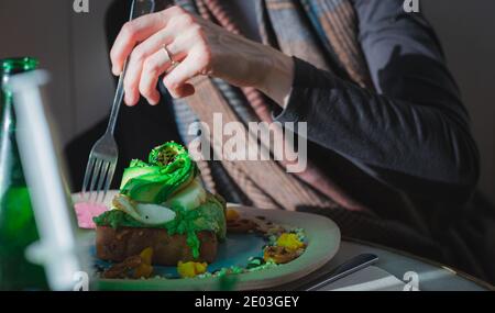 Une jeune femme mangeant un toast d'avocat Banque D'Images