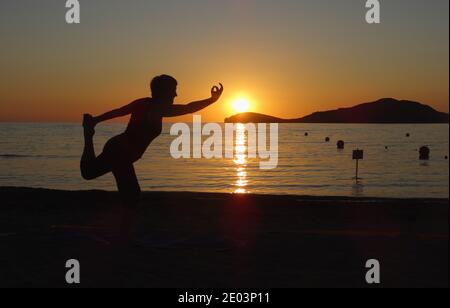 Lemnos Grèce 15 septembre 2017 Yoga au coucher du soleil sur la plage de Plati , Myrina, Ile de Lemnos dans les îles grecques avec vue sur Loutra en arrière-plan Banque D'Images