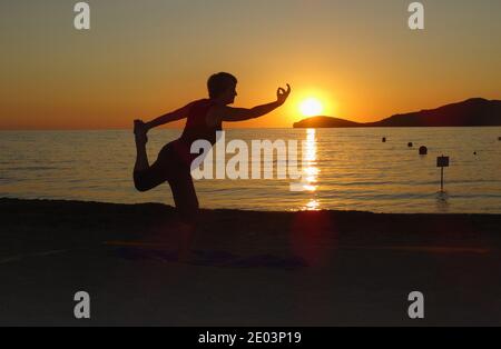 Lemnos Grèce 15 septembre 2017 Yoga au coucher du soleil sur la plage de Plati , Myrina, Ile de Lemnos dans les îles grecques avec vue sur Loutra en arrière-plan Banque D'Images