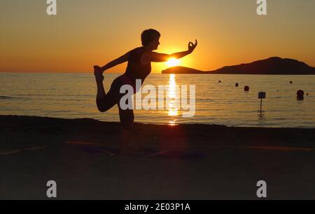 Lemnos Grèce 15 septembre 2017 Yoga au coucher du soleil sur la plage de Plati , Myrina, Ile de Lemnos dans les îles grecques avec vue sur Loutra en arrière-plan Banque D'Images