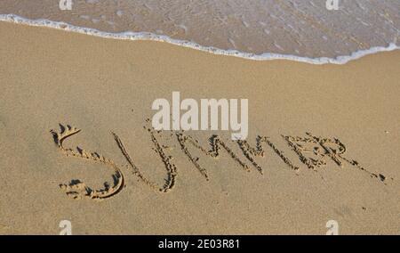 Le mot été écrit dans le sable sur la plage Banque D'Images