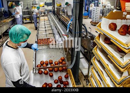 Capelle aan den IJssel, pays-Bas. 29 décembre 2020. Les employés de la boulangerie artisanale Klootwijk servant à la pâte à pain font frire des beignets pendant la crise du Covid-19. Entre Noël et la Saint-Sylvestre, des milliers de balles sortent de la graisse par jour. Un homme cuit oliebollen (Donuts hollandais traditionnels) avec un masque facial pendant la crise pandémique Covid-19 et le verrouillage dur. Capelle aan den IJssel, pays-Bas, le 29 décembre 2020. Photo de Robin Utrecht/ABACAPRESS.COM crédit: ABACAPRESS/Alay Live News Banque D'Images