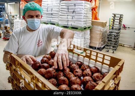 Capelle aan den IJssel, pays-Bas. 29 décembre 2020. Les employés de la boulangerie artisanale Klootwijk servant à la pâte à pain font frire des beignets pendant la crise du Covid-19. Entre Noël et la Saint-Sylvestre, des milliers de balles sortent de la graisse par jour. Un homme cuit oliebollen (Donuts hollandais traditionnels) avec un masque facial pendant la crise pandémique Covid-19 et le verrouillage dur. Capelle aan den IJssel, pays-Bas, le 29 décembre 2020. Photo de Robin Utrecht/ABACAPRESS.COM crédit: ABACAPRESS/Alay Live News Banque D'Images