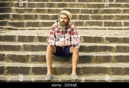 Le lot de préparation est versé sur le café. Homme avec barbe qui boit du café. Homme barbu boisson fond urbain. Hipster se détendre dans les escaliers. Repos. Prenez le café. Dose de caféine. Filtrer le café. Banque D'Images