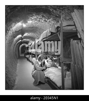 WW2 London Blitz femme s'agenouillant à côté d'un lit d'enfant, dans un tunnel de raid aérien souterrain pendant le bombardement de Londres pendant la Seconde Guerre mondiale Frissell, Toni, 1907-1988, photographe [1945 janv.] - Guerre mondiale, 1939-1945--Défense civile--Angleterre--Londres--1940-1950 - tunnels--Angleterre--Londres--1940-1950 abris aériens en raid--Angleterre--Londres--1940-1950 Banque D'Images