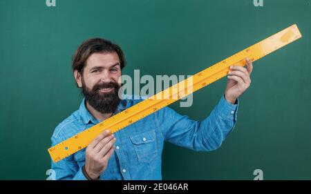 préparez-vous à l'examen. maître de conférences sur la géométrie. retour à l'école. formation formelle. journée du savoir. professeur à barbe mature utilisant des outils de règle mathématique. homme brutal travaille en classe avec un tableau noir. Banque D'Images