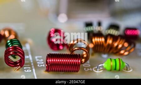 Gros plan des enroulements de fils de bobines à noyau d'air de couleur pour la réception du signal de radiofréquence. Détails de la carte de circuit imprimé. Inductances électroniques RF à l'intérieur du module TV. Banque D'Images