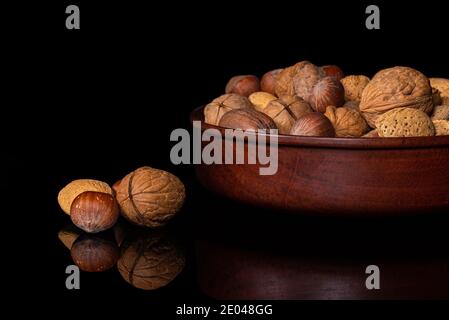 Bol en bois rempli de noix, de pacanes, d'amandes, de noisettes en carapace Banque D'Images