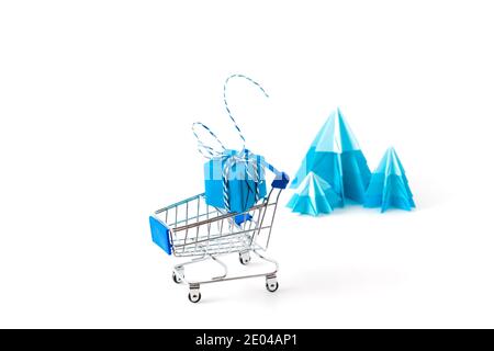 Chariot avec boîte cadeau bleue sur fond blanc. Copier l'espace pour votre texte. Banque D'Images