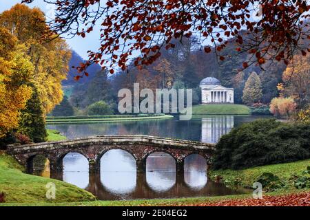 Le pont palladien à cinq arches avec le Panthéon au loin à Stourhead dans le Wiltshire, Angleterre. Banque D'Images