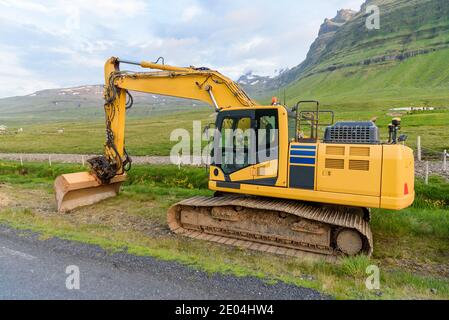 Vider la pelle hydraulique sur un chantier de construction le long d'une route de montagne une soirée d'été partiellement nuageux Banque D'Images