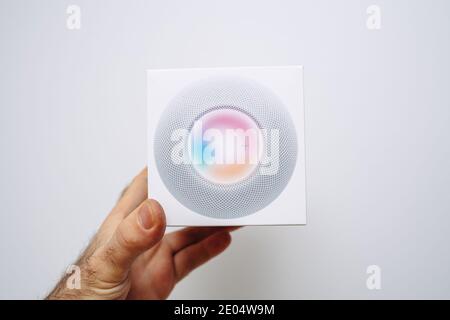 Paris, France- 9 décembre 2020: POV perspective personnelle main mâle tenant de nouveaux ordinateurs Apple HomePod assistant personnel périphérique son avec Siri - isolé sur blanc Banque D'Images