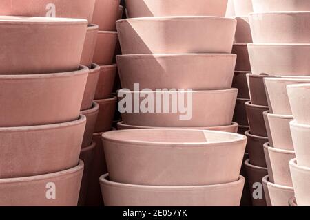 Pots de fleurs en argile rose aux rayons du soleil, empilés les uns sur les autres. Banque D'Images