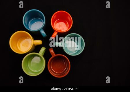 Ensemble de tasses à café colorées sur fond noir Banque D'Images