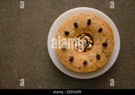 Gâteau fait maison au Rawa et aux fruits secs dans une assiette blanche Table gris foncé Banque D'Images