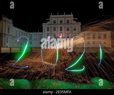 Oranienburg, Allemagne. 29 décembre 2020. Une femme a dessiné l'année 2021 avec une lampe de poche devant le château d'Oranienburg (Brandebourg). (Exposition longue durée) crédit : Paul Zinken/dpa/Alamy Live News Banque D'Images