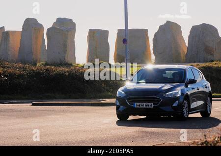 Plage de Chesil. 29 décembre 2020. Météo Royaume-Uni. Une voiture passe devant les pierres de la mémoire, un mini monument « Stonehenge », lors d'une journée froide mais ensoleillée pour l'île de Portland. Crédit : stuart fretwell/Alay Live News Banque D'Images