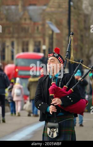 Un écossais habillé traditionnellement dans un kilt joue de la musique traditionnelle écossaise sur des cornemuses devant le Parlement, sur le pont de Westminster. Ian Blackford affirme que le parti national écossais (SNP) va voter contre l'accord commercial entre l'UE et le Royaume-Uni, car il affirme que c'est un désastre pour l'Écosse. Malgré les protestations du SNP, l'accord commercial UE-Royaume-Uni a été promulgué et le Royaume-Uni a quitté l'UE le 1er janvier 2021. Banque D'Images