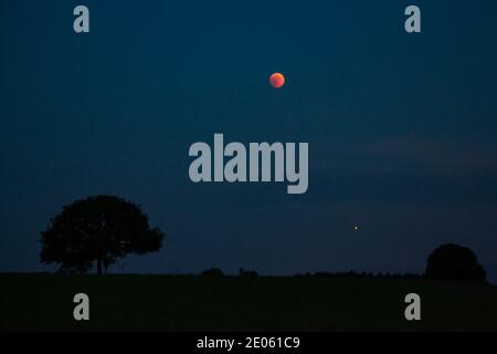 Lune de sang et Mars illuminant pendant l'éclipse lunaire totale sur l'Allemagne, juillet 2018 Banque D'Images