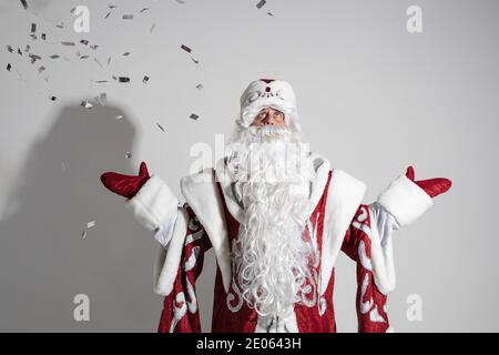 le givre du père est un long manteau chaud, des moufles rouges et un chapeau pour fêter la nouvelle année Banque D'Images