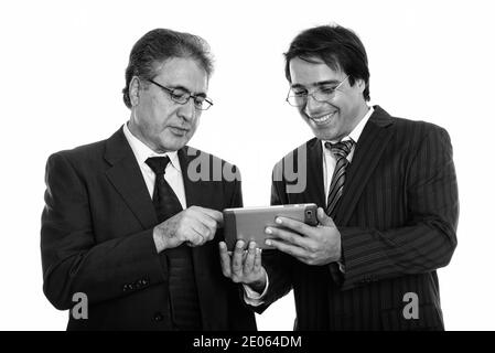 Portrait of happy young et senior businessman smiling persique lors de l'utilisation de digital tablet Banque D'Images