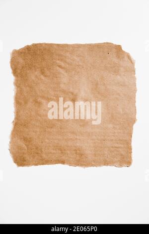 Morceau de papier brun carré déchiré avec bords déchirés isolés sur blanc. Banque D'Images