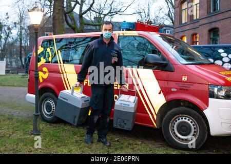 Hanovre, Allemagne. 30 décembre 2020. Un pompier transporte des boîtes froides avec le vaccin Corona depuis un véhicule d'urgence jusqu'à l'entrée de la maison de soins 'Staft zum Heiligen Geist'. L'installation est la première dans la région de Hanovre à recevoir le vaccin Corona. Credit: Moritz Frankenberg/dpa/Alay Live News Banque D'Images