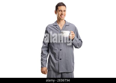 Jeune homme souriant en pyjama tenant une tasse de thé isolé sur fond blanc Banque D'Images