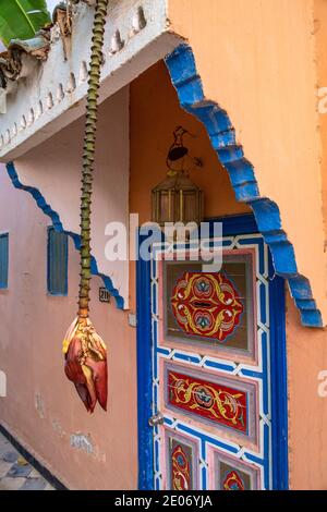 Taroudant, Maroc. 26 février 2020. Fleur de banane suspendue devant la porte peinte de l'hôtel Salam Palace le 26 février 2020 au Maroc. Banque D'Images