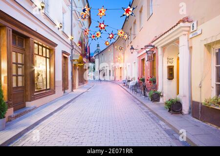 Vue nocturne de la rue Stikliai illuminée dans le quartier juif de la vieille ville de Vilnius, Lituanie. Banque D'Images