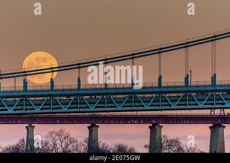 Pleine lune s'élevant le long du pont suspendu Triboro RFK New York City East River Banque D'Images