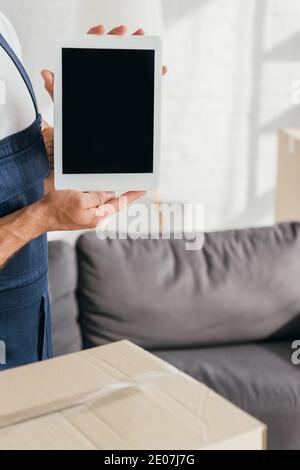 vue rognée du motionnaire en uniforme tenant la tablette numérique avec écran vide dans l'appartement Banque D'Images