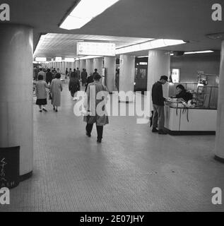 Années 1960, navetteurs japonais historiques sur une plate-forme du métro de Tokyo, Japon. Banque D'Images