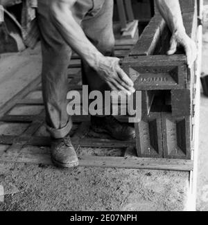 années 1950, historique, un ouvrier posant des briques de fletton sur un cadre en bois. Fabriqués à partir d'argile Oxford par la London Brick Company à leurs briques Stegartby, ces briques ont été fabriquées en volume comme des briques utilitaires, sans aucun attrait esthétique. Dans la période de l'après-guerre, on estime qu'à un certain point la production sur le site a atteint 16 millions de briques par jour, alors que les travaux étaient les plus importants au monde. Le nom de commerce 'Phorpres' provient du fait que la brique de Fletton de la société LBC a été pressée deux fois dans chaque direction - quatre pressés - et si cette phrase est prononcée rapidement, elle devient Phorpres! Banque D'Images