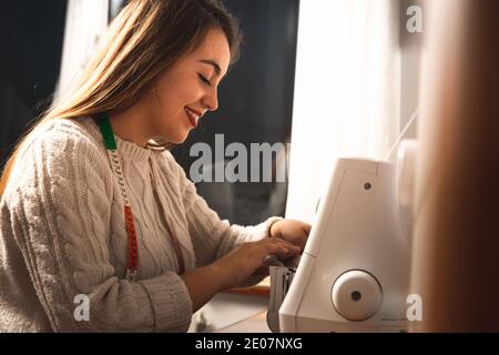 Jeune femme utilisant une machine à coudre Banque D'Images