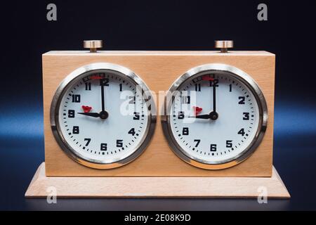 Horloge d'échecs analogique isolée sur fond sombre Banque D'Images