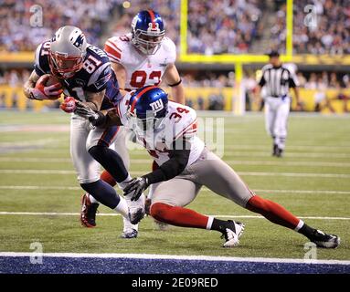 L'extrémité serrée Aaron Hernandez (81) des New England Patriots évite l'attaque de la sécurité forte Deon Grant (34) des New York Giants à marquer sur l'ouverture de la deuxième moitié du Super Bowl XLVI au stade Lucas Oil à Indianapolis, Indiana, USA le 05 février 2012. Photo de Lionel Hahn/ABACAPRESS.COM Banque D'Images
