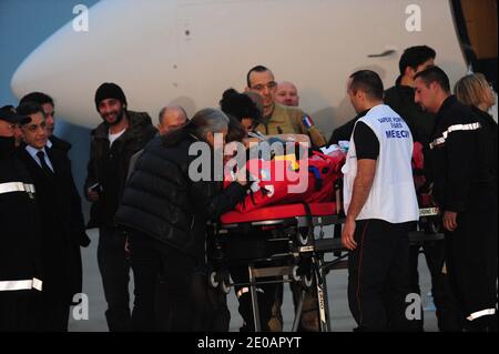 La journaliste française Edith Bouvier est photographiée avec sa famille près du président français Nicolas Sarkozy et de Wiliam Daniels sur le tarmac de l'aéroport militaire de Villacoublay à l'extérieur de Paris le 2 mars 2012, après l'atterrissage d'un avion transportant les journalistes français Edith Bouvier et William Daniels. Edith Bouvier, 31 ans, et William Daniels, 34 ans, se sont enfuis au Liban après avoir été piégé pendant des jours dans la ville syrienne éclair de Homs. Le journaliste du Figaro Bouvier a de multiples fractures suite à une attaque à la roquette du 22 février contre un centre médiatique rebelle de fortune à Baba AMR à Homs, dans lequel les États-Unis vétera Banque D'Images